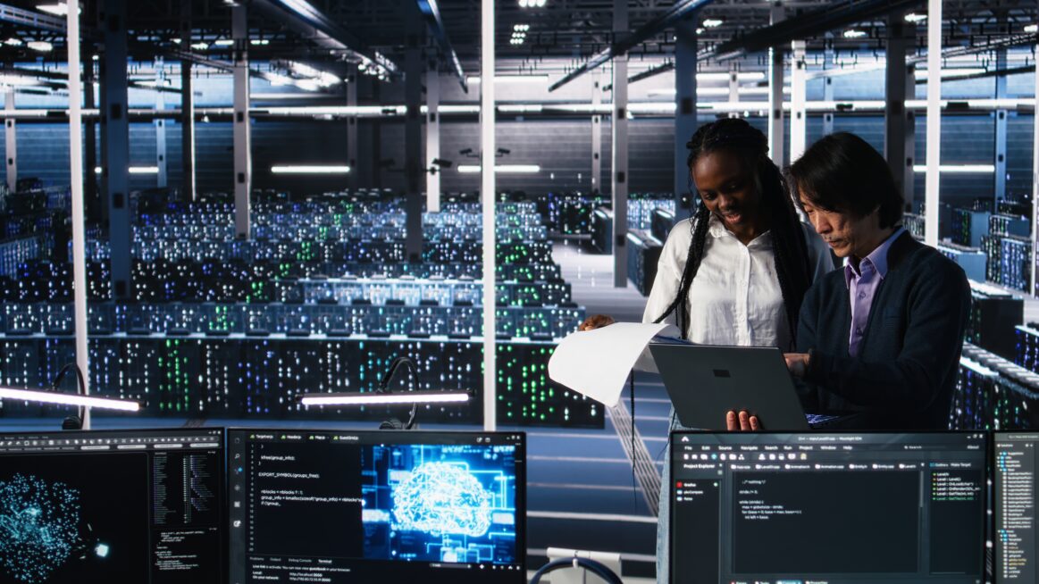 Data Center Engineers Managing Ai Systems Looking Paperwork 1163x654